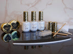 A collection of nail dip powder kit items including bottles of glue, activate, and gloss, a jar of dip powder, a nail tool kit with a file and brush, and additional replacement brush/cap.