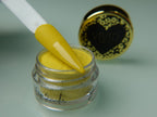 A collection of nail dip powder kit items including bottles of glue, activate, and gloss, a jar of dip powder, a nail tool kit with a file and brush, and additional replacement brush/cap.