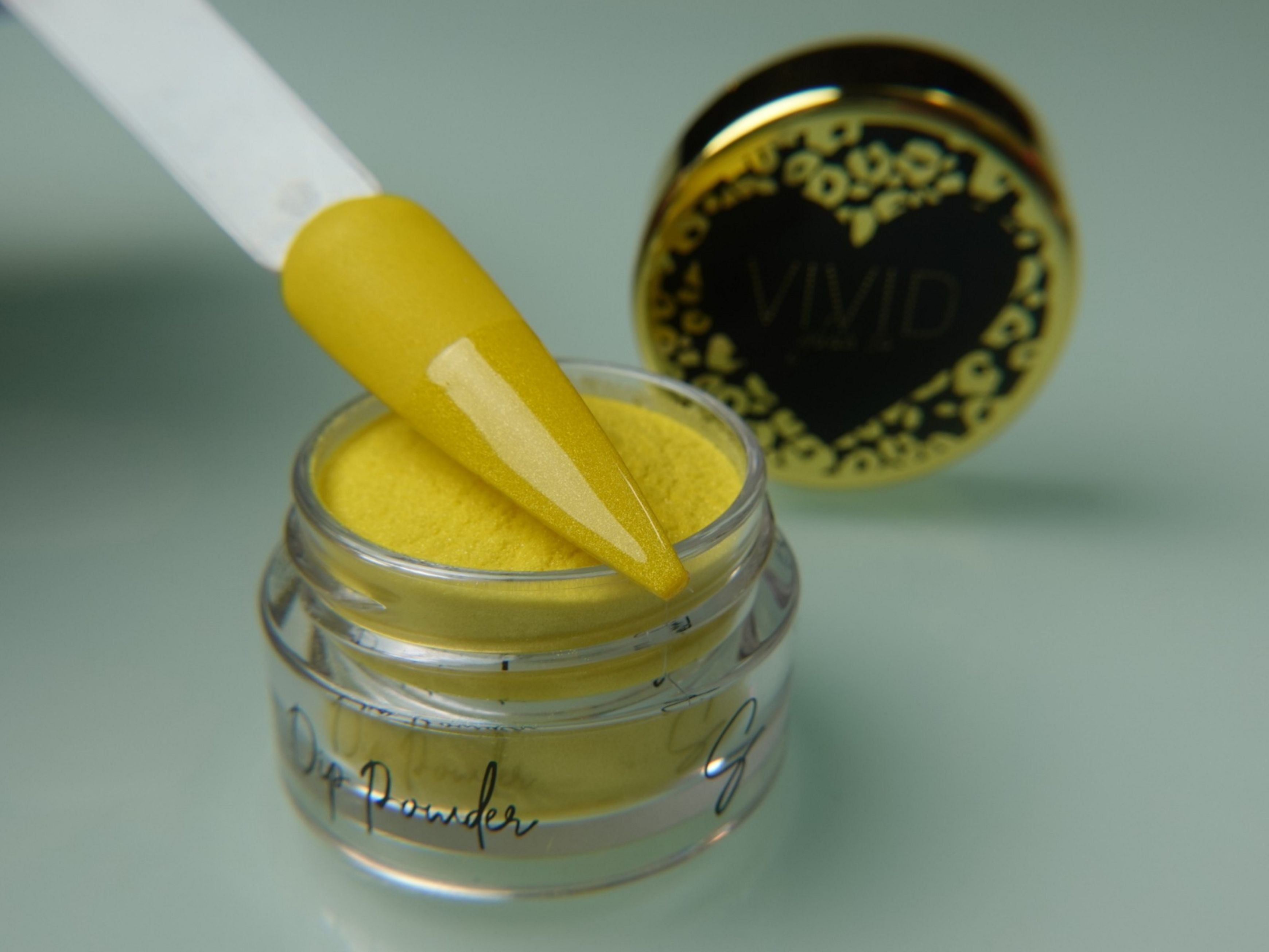 A collection of nail dip powder kit items including bottles of glue, activate, and gloss, a jar of dip powder, a nail tool kit with a file and brush, and additional replacement brush/cap.