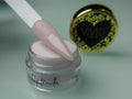 A collection of nail dip powder kit items including bottles of glue, activate, and gloss, a jar of dip powder, a nail tool kit with a file and brush, and additional replacement brush/cap.