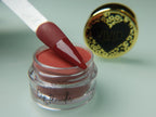 A collection of nail dip powder kit items including bottles of glue, activate, and gloss, a jar of dip powder, a nail tool kit with a file and brush, and additional replacement brush/cap.