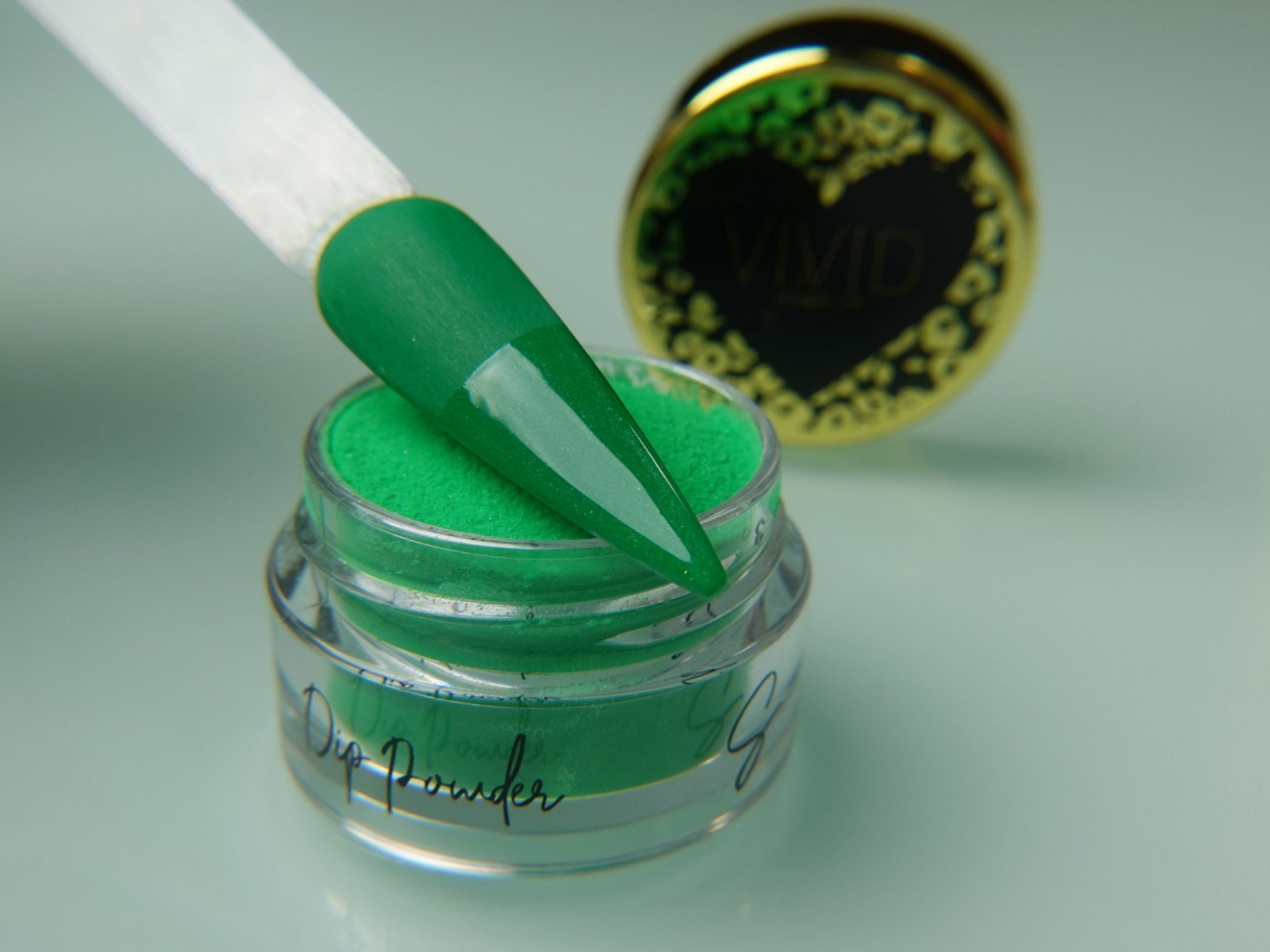 A collection of nail dip powder kit items including bottles of glue, activate, and gloss, a jar of dip powder, a nail tool kit with a file and brush, and additional replacement brush/cap.