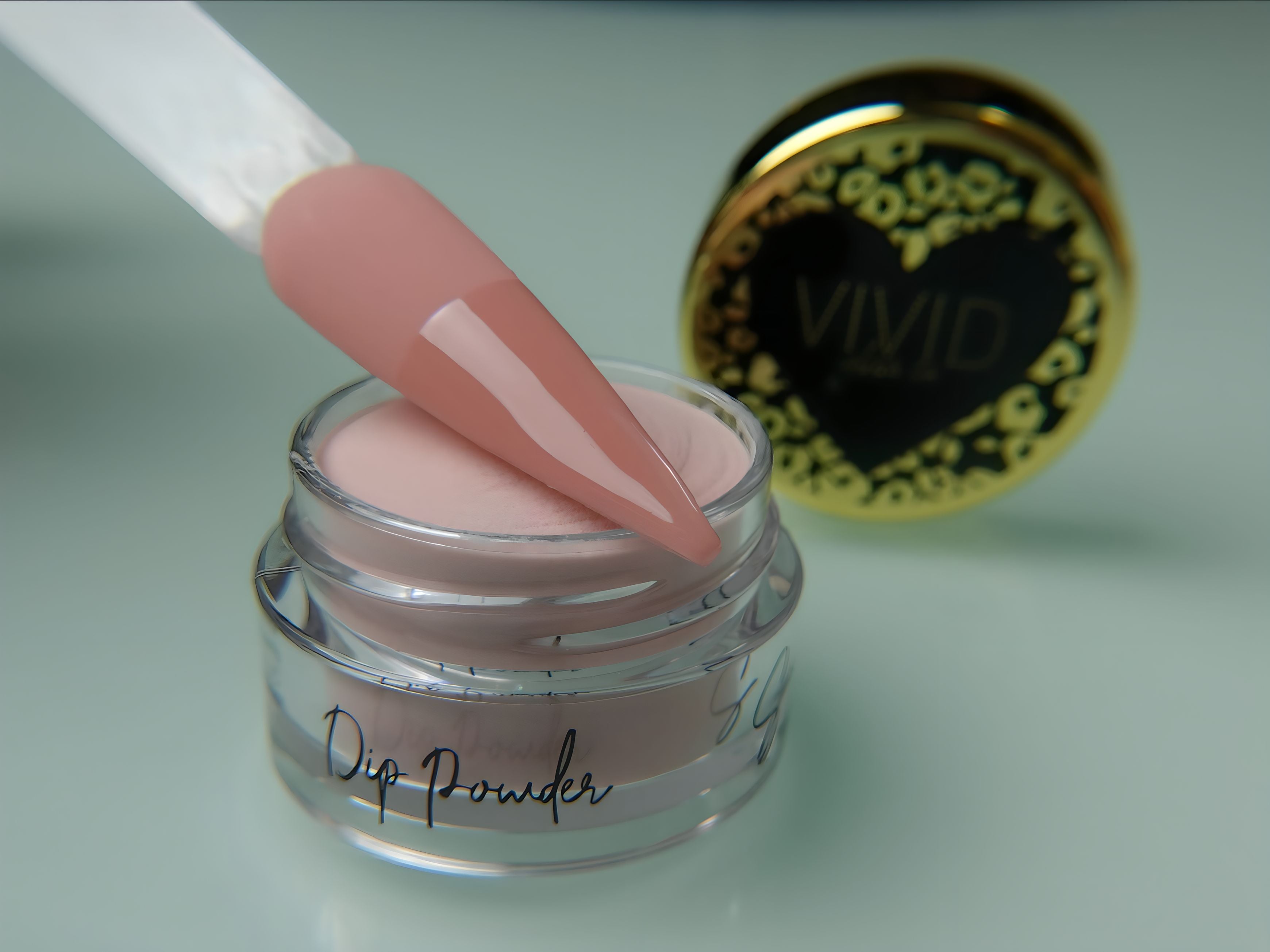 A collection of nail dip powder kit items including bottles of glue, activate, and gloss, a jar of dip powder, a nail tool kit with a file and brush, and additional replacement brush/cap.