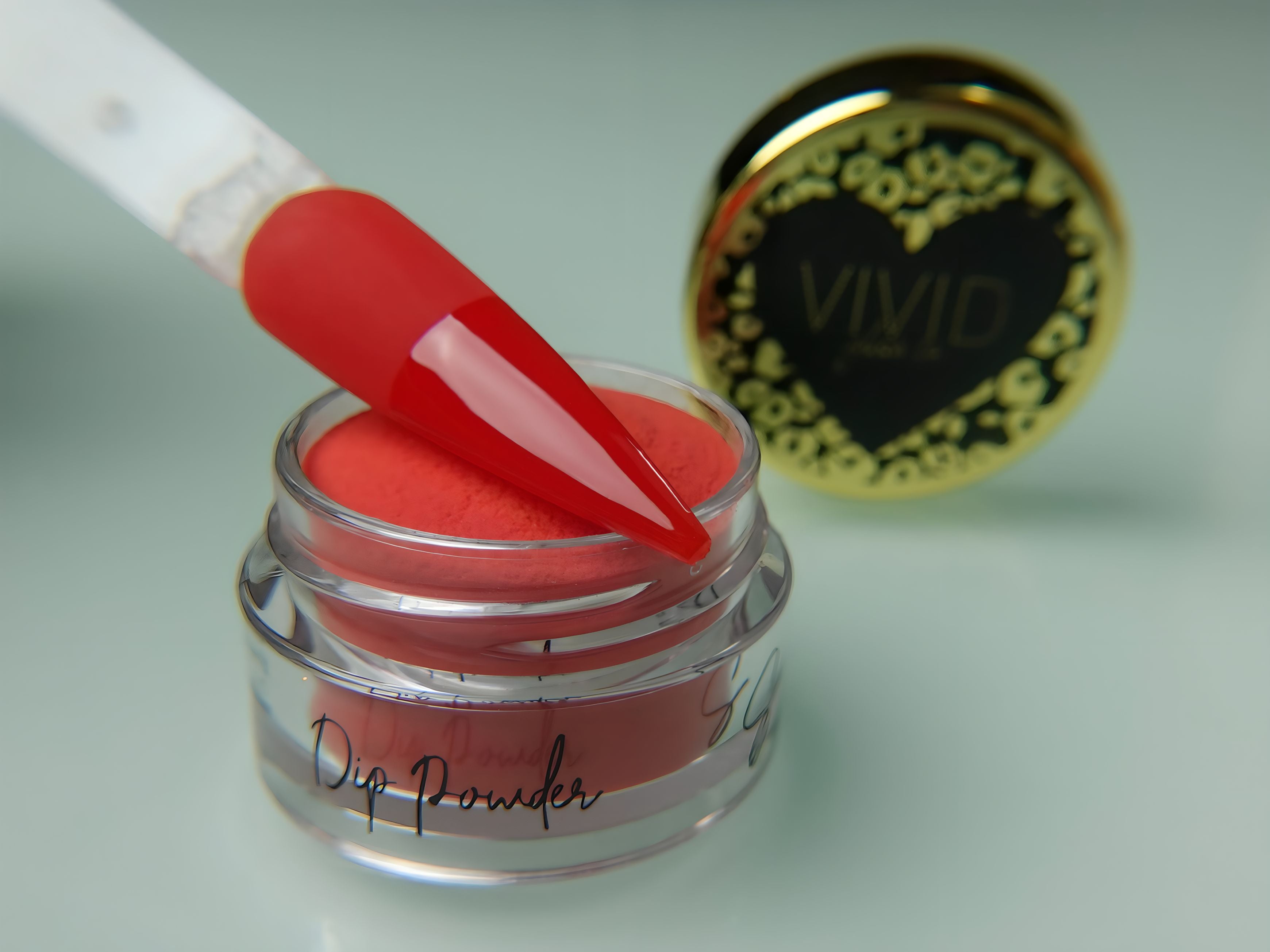A collection of nail dip powder kit items including bottles of glue, activate, and gloss, a jar of dip powder, a nail tool kit with a file and brush, and additional replacement brush/cap.